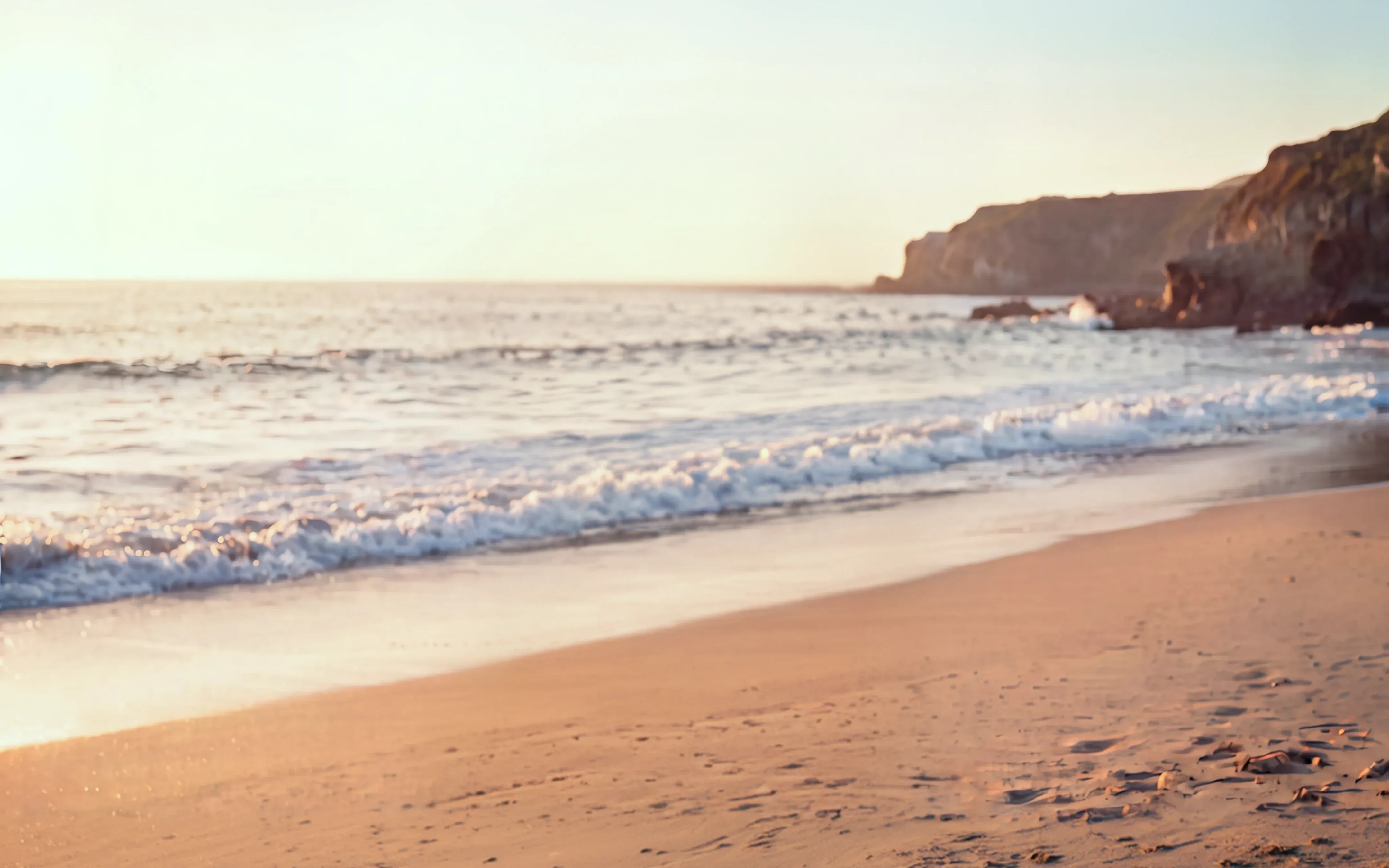 A couple embracing on a sunlit beach at golden hour
