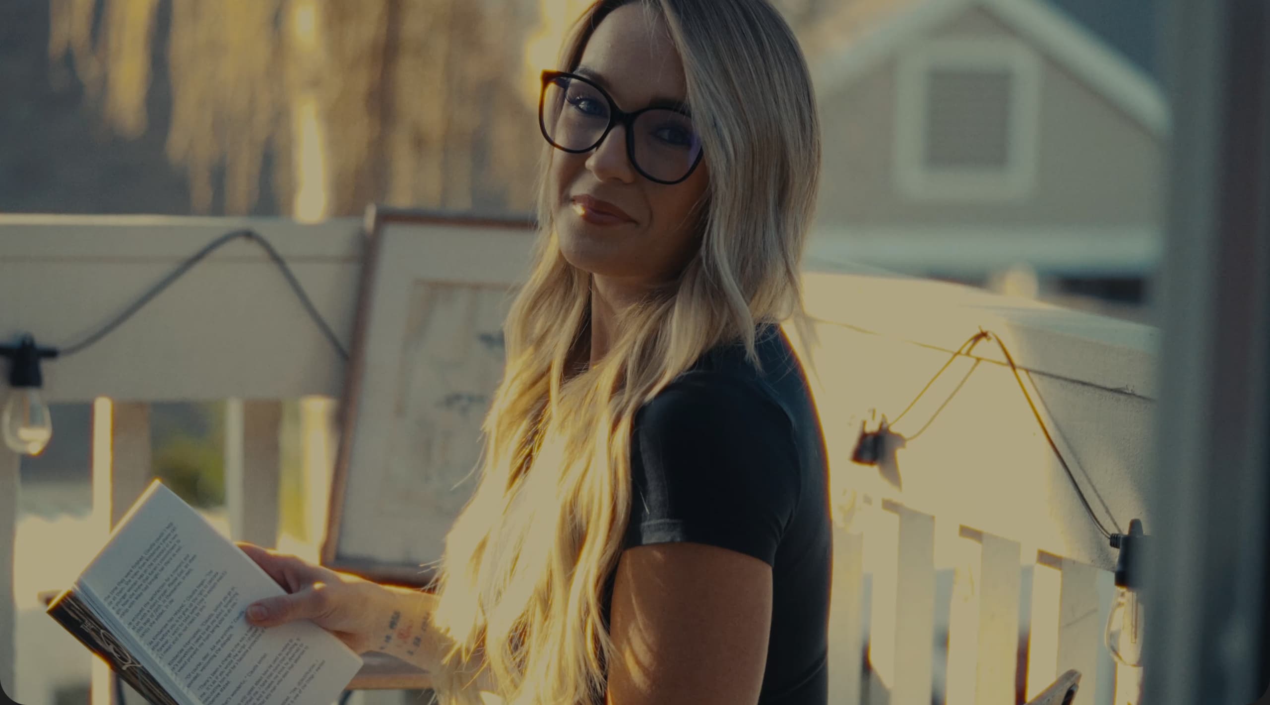 Woman reading a book outdoors at golden hour