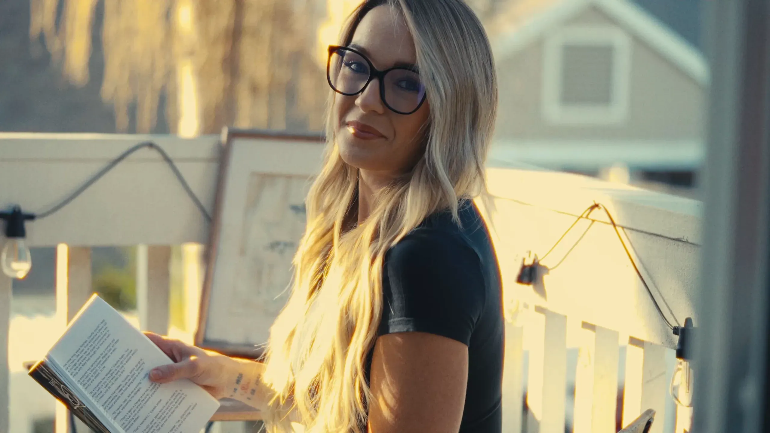 Laurin reading on a sunlit porch at golden hour